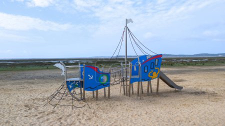 parque infantil vacío en la playa de arena en la ciudad de Ares con un bonito cielo azul