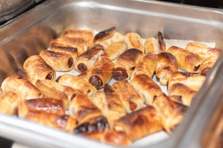 Photo for Buffet table with a chaffing dish full of wrapped pigs in a blanket for the party guests to eat. - Royalty Free Image