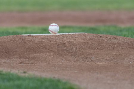 Téléchargez les photos : Le caoutchouc de tangage a une nouvelle balle propre sur le monticule intérieur de baseball pour la journée de jeu. - en image libre de droit