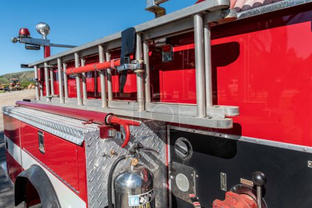 Foto de Hacha de recogida de fuego de playa y escalera de extensión resistente está firmemente asegurado al lado del camión de bomberos rojo. - Imagen libre de derechos