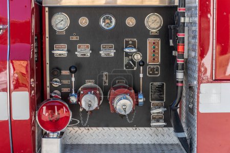 Foto de Vista cercana del camión de bomberos trasero tiene controles para descarga, drenaje, llenado de tanques, alivio y válvula de succión, todos ubicados en un panel. - Imagen libre de derechos