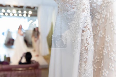 Braut probiert verschiedene Brautkleider an, um zu sehen, welcher Spitzenstil am besten aussieht.