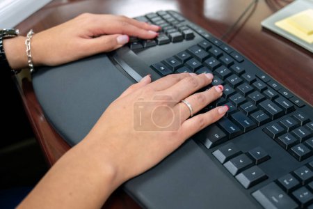 Feminine hands entering keystrokes on the keyboard for statistical data analysis.