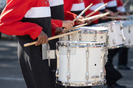 Línea de tambor de banda de marcha de la escuela secundaria manteniendo el ritmo mientras participa en el desfile local.