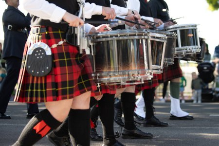 Línea de tambor irlandesa con escocesas y salpicaduras en honor a la tradición irlandesa durante el desfile del Día de San Patricio.