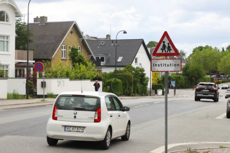 Photo for Hellerup, Denmark - June 14, 2022: Road sign warning for children near a school on a suburban street with detached houses. - Royalty Free Image