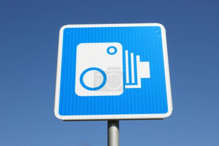 Tiefansicht eines finnischen Verkehrsschildes mit einem Symbol für automatische Verkehrsüberwachungskamera vor blauem Himmel.