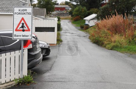 Photo for Vikhammer, Norway - September 30, 2023: Information sign in Norwegian in a residential area with single-family houses urges to drive carefully because children are playing in the area. - Royalty Free Image