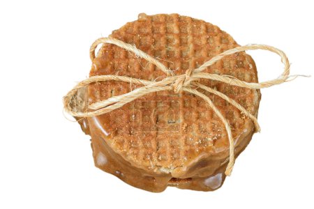 Photo for Several stacked stroopwafels, with a sisal bow and sugared syrup_white background. - Royalty Free Image