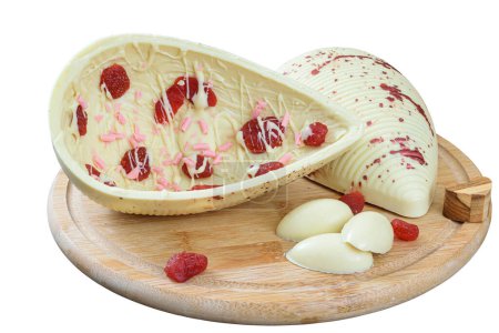 Photo for A white chocolate Easter egg with candied strawberries on a wooden plate. - Royalty Free Image