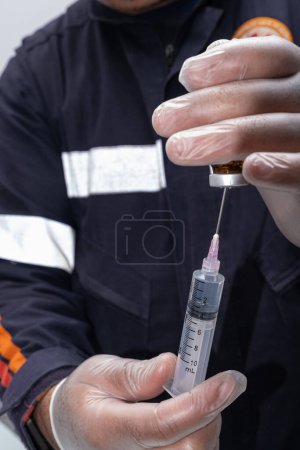 Foto de Enfermera con guante protector, eliminando antiinflamatorios de la ampolla _ vertical. - Imagen libre de derechos
