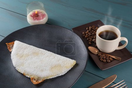 Téléchargez les photos : Tapioca au fromage mozzarella fondu, à côté d'une tasse de fond en bois noir coffee _ blue. Cuisine traditionnelle brésilienne _ 2. - en image libre de droit