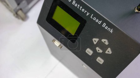Foto de Turned off capacity battery load bank on white surface. Control panel with display and buttons. - Imagen libre de derechos