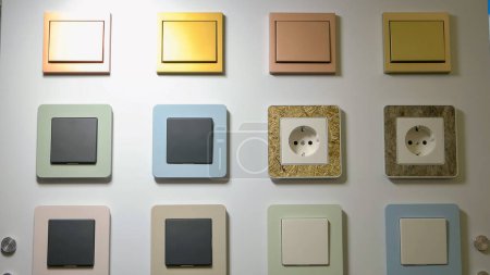 Foto de Varios colores swithches y enchufes en la pared. Energía eléctrica para el hogar. - Imagen libre de derechos