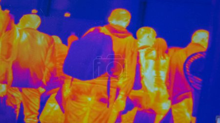 Téléchargez les photos : Infrared thermal vision of people walking indoors. Scanning for source of virus infection or items for terrorism. - en image libre de droit