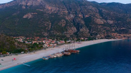 Photo for Aerial panoramic view from drone of coastal town and mountains. Yachts and boats parked on the beach of resort town. - Royalty Free Image