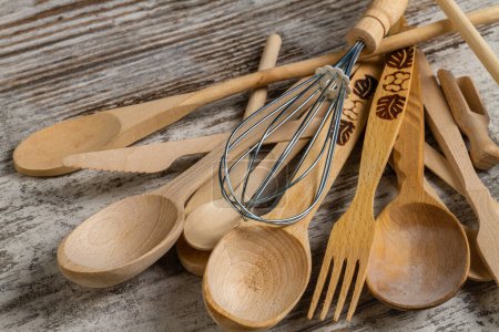 Téléchargez les photos : De nombreux ustensiles de cuisine rustiques en bois se ferment. Cuillères avec fourchettes et fouet. - en image libre de droit