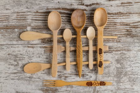 Foto de Conjunto de cucharas y tenedores rústicos de madera con vista superior. Oldfashined utensilios de cocina retro. - Imagen libre de derechos