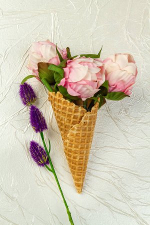 Photo for Ice cream cone with flowers and purple clover. Vertical shot white background. - Royalty Free Image