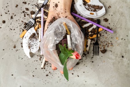 Foto de Cerca de mano sosteniendo bolsa de plástico con flor de rosa y cigarrillos. - Imagen libre de derechos