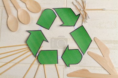 Téléchargez les photos : Symbole de recyclig vue du dessus et ustensiles en bois. Cuillères avec couteaux et écouteurs. - en image libre de droit