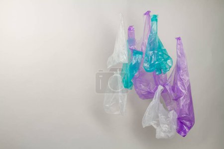 Téléchargez les photos : Ensemble de sacs en plastique colorés suspendus avec espace de copie. Isolé sur fond blanc. - en image libre de droit