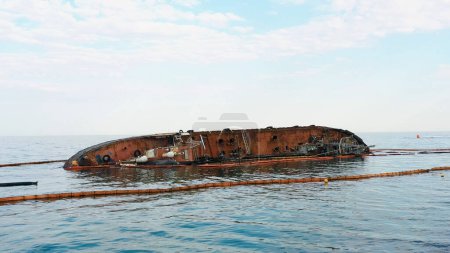 Téléchargez les photos : Sunken drowned tanker ship near the aground. Broken rusty ship on the shallow water. - en image libre de droit