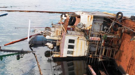 Foto de Overturned oil tanker ship in the shallow water. Close up sunken drowned oil tanker after the wreck. - Imagen libre de derechos