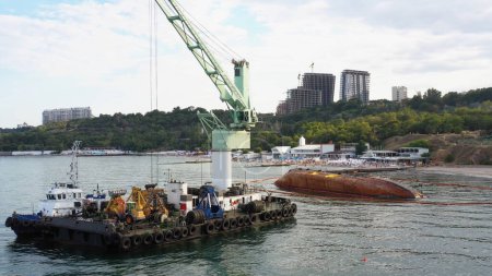 Téléchargez les photos : Rescue wrecked oil tanker ship in Odessa. Old rusty ship lie on its side aground. Black Sea coast. - en image libre de droit