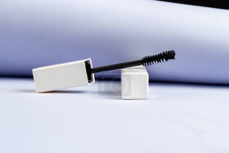 Photo for Close up black mascara brush in white tube. White paper background. - Royalty Free Image