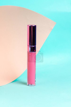 Photo for Close up of pink lip gloss tube. Colorful Turquoise background. - Royalty Free Image