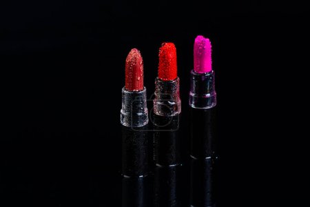 Téléchargez les photos : Set pf trois rouges à lèvres isolés sur fond noir. Rouge une couleur pourpre. - en image libre de droit