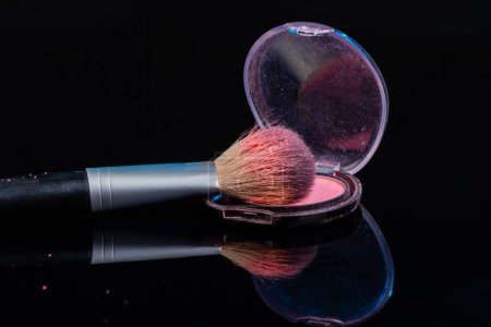 Foto de Make up brush and round cosmetic powder box. Isolated on black. - Imagen libre de derechos