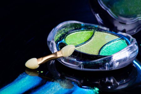 Photo for Close up of colorful eye shadow palette and brush. Color makeup with green shimmer shadows. - Royalty Free Image