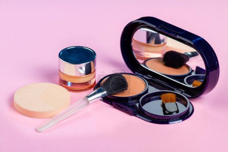 Téléchargez les photos : Cosmétique maquillage boîte de poudre avec miroir. Isolé sur fond rose. - en image libre de droit
