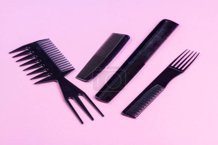 Foto de Set of black professional salon barber hair combs. Isolated on pink. - Imagen libre de derechos