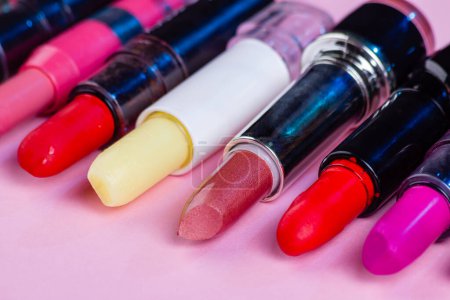 Téléchargez les photos : Gros plan ensemble de divers rouges à lèvres multicolores. Isolé sur rose. - en image libre de droit