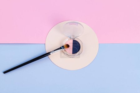 Photo for Top view round cosmetic powder box and brush. Blue and pink background. - Royalty Free Image