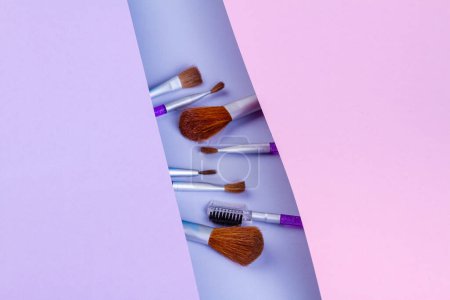 Téléchargez les photos : Top view set of makeup brushes of different size. Covered with paper from both sides. - en image libre de droit