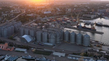 Téléchargez les photos : Drone view of urban city scape with sea port. Grain terminals in Odessa. Evening sunset light. - en image libre de droit