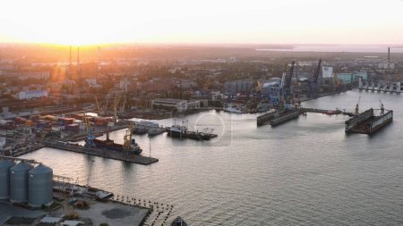 Téléchargez les photos : Drone view of urban sea port with grain terminals. Evening sunset light. - en image libre de droit