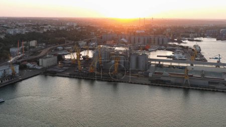 Téléchargez les photos : Port maritime avec grues à tour et terminaux à grain. Lumière du coucher du soleil du soir. - en image libre de droit