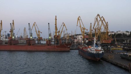 Foto de Cisternas y grúas de carga en el puerto de Odesa. Paisaje industrial en el cielo crepuscular. - Imagen libre de derechos