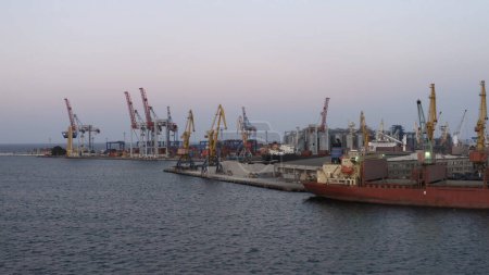 Téléchargez les photos : Drone view of sea port with ship and tower cranes. Evening twilight sky. - en image libre de droit