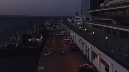 Téléchargez les photos : Cruise ships and cars at sea port at night. Blackout in Odessa, Ukraine. Evening twilight sky. - en image libre de droit