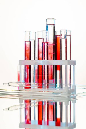 Foto de Conjunto de probetas de laboratorio con muestras de sangre. Fondo blanco plano vertical. - Imagen libre de derechos