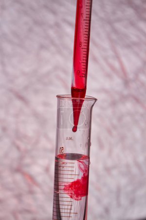 Photo for Close up pipette dropping blood into test tube. Blood test and analysis in medical research laboratory. - Royalty Free Image