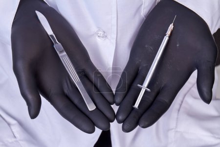 Photo for Close up doctors hands in gloves holding tools for cosmetic surgery. Scalpel and syringe. - Royalty Free Image