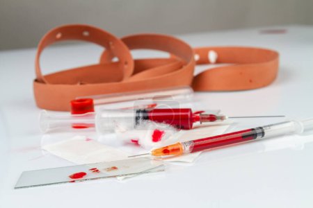 Photo for Close up syringes filled with red blood. Glass sheet test. - Royalty Free Image