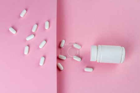 Photo for White medicine pill bottle on pink background. Top view flat lay. - Royalty Free Image